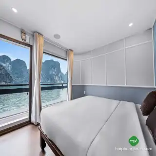 Example of a private Halong day-cruise room with a bed and windows facing the bay